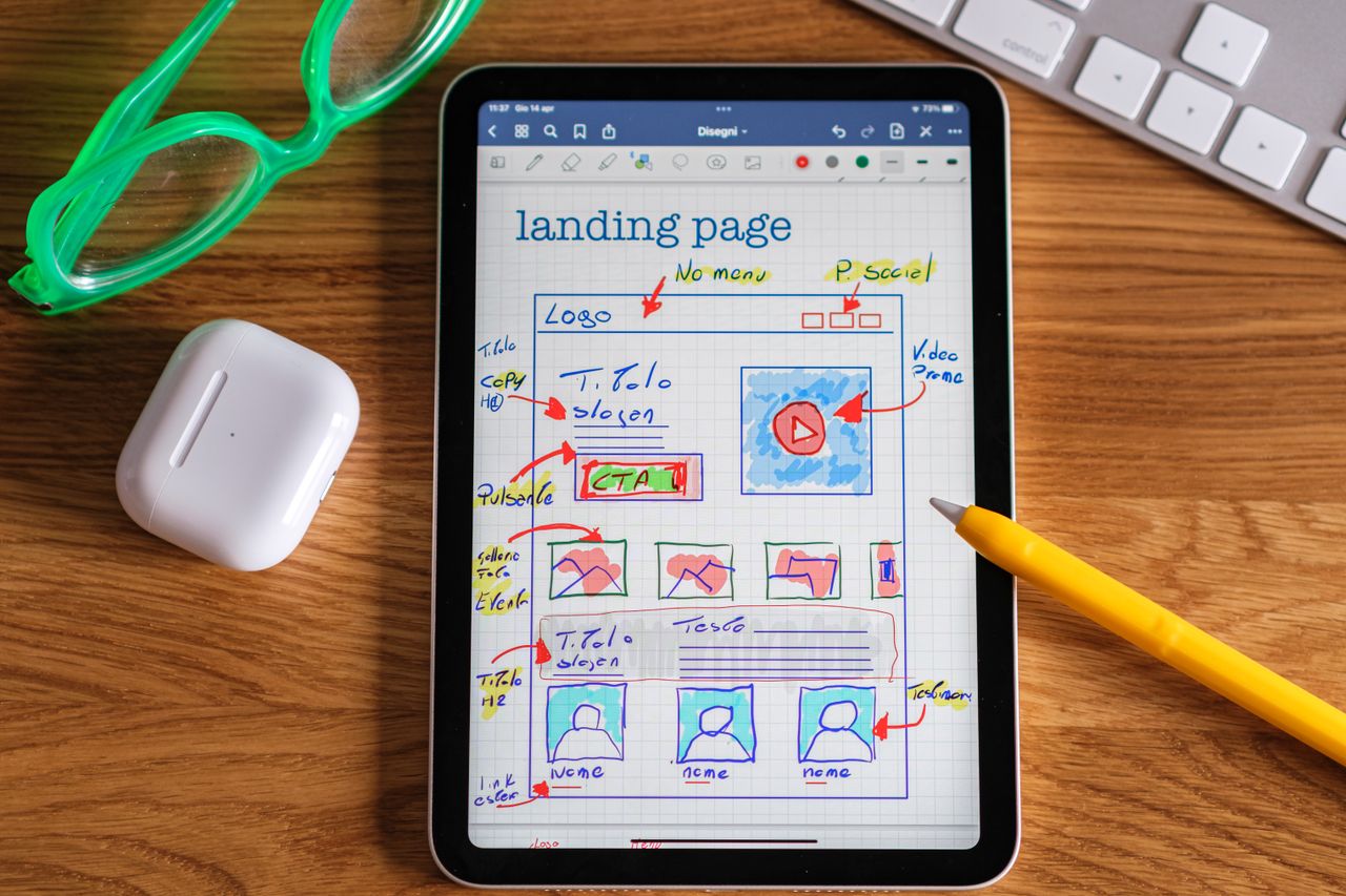 services-02 Close-up of tablet showing a hand-drawn landing page design, ideal for web development concepts.